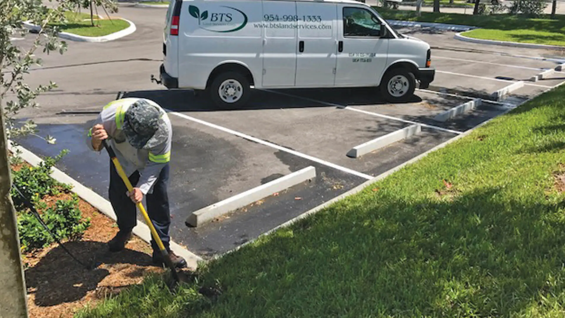 Employee working on commercial property's landscape.